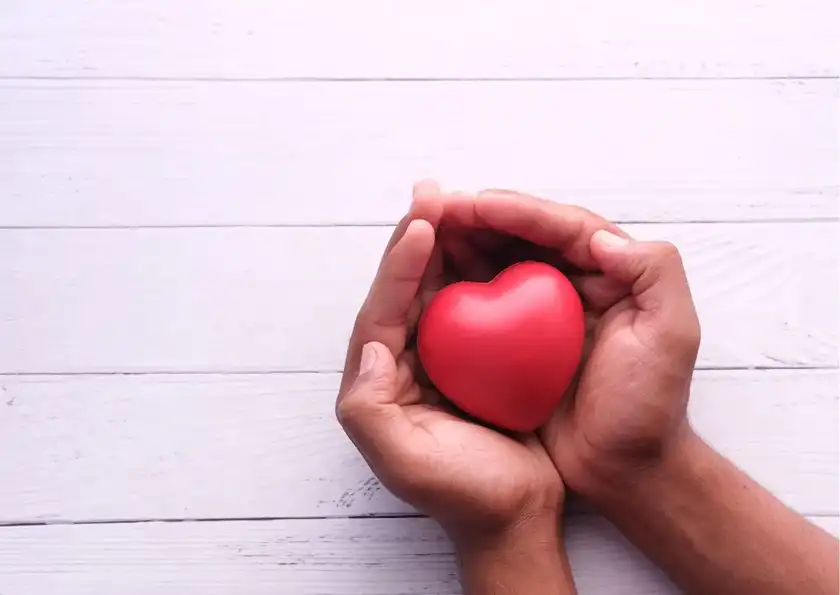 Mains offrant un cœur rouge, symbole du Giving Tuesday 2026, journée mondiale de la générosité en entreprise